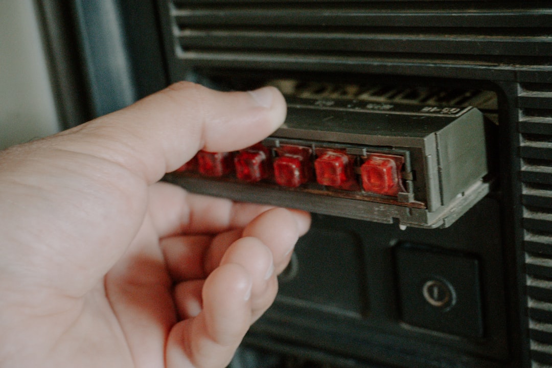 Hand inserts red-lit component into device.